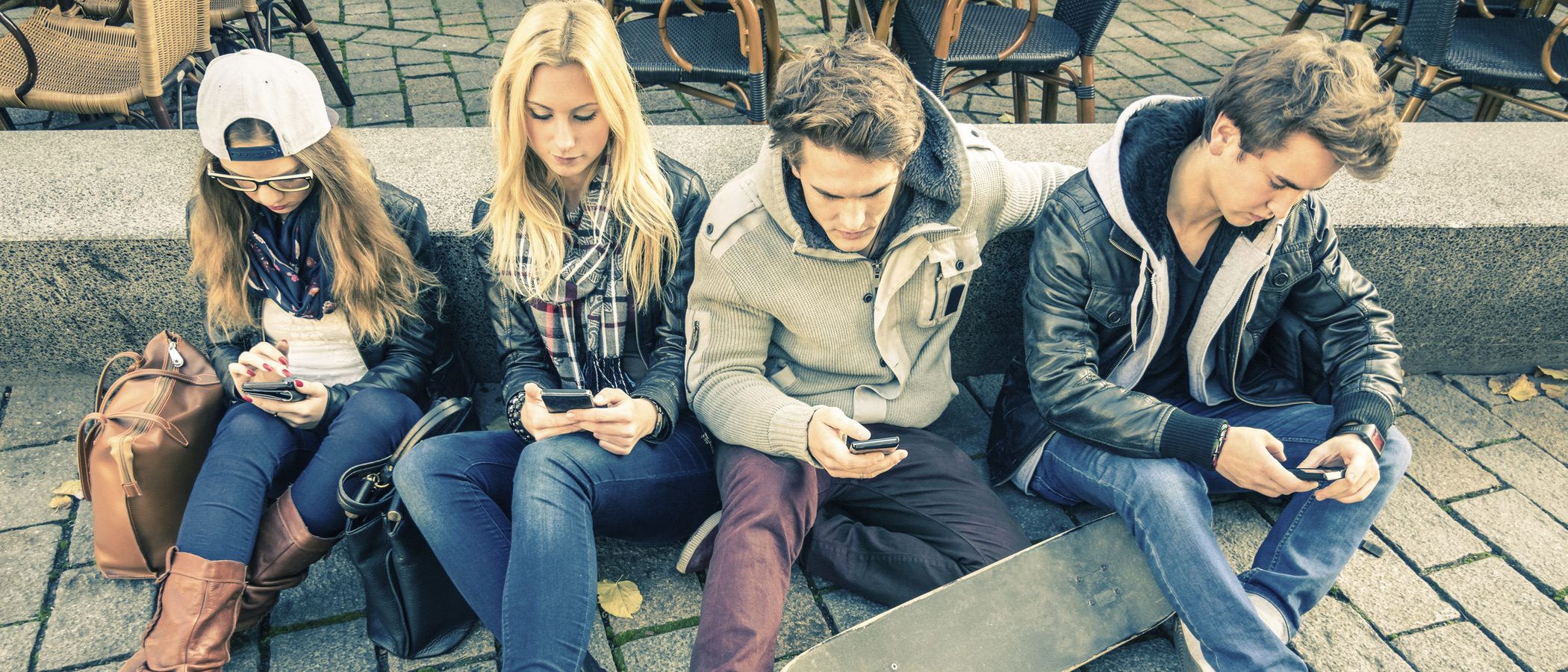 Psicóloga para adolescentes en Valencia - Jóvenes sentados usando el móvil