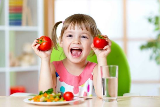 especialistas en nutrición en Valencia - niña con tomates